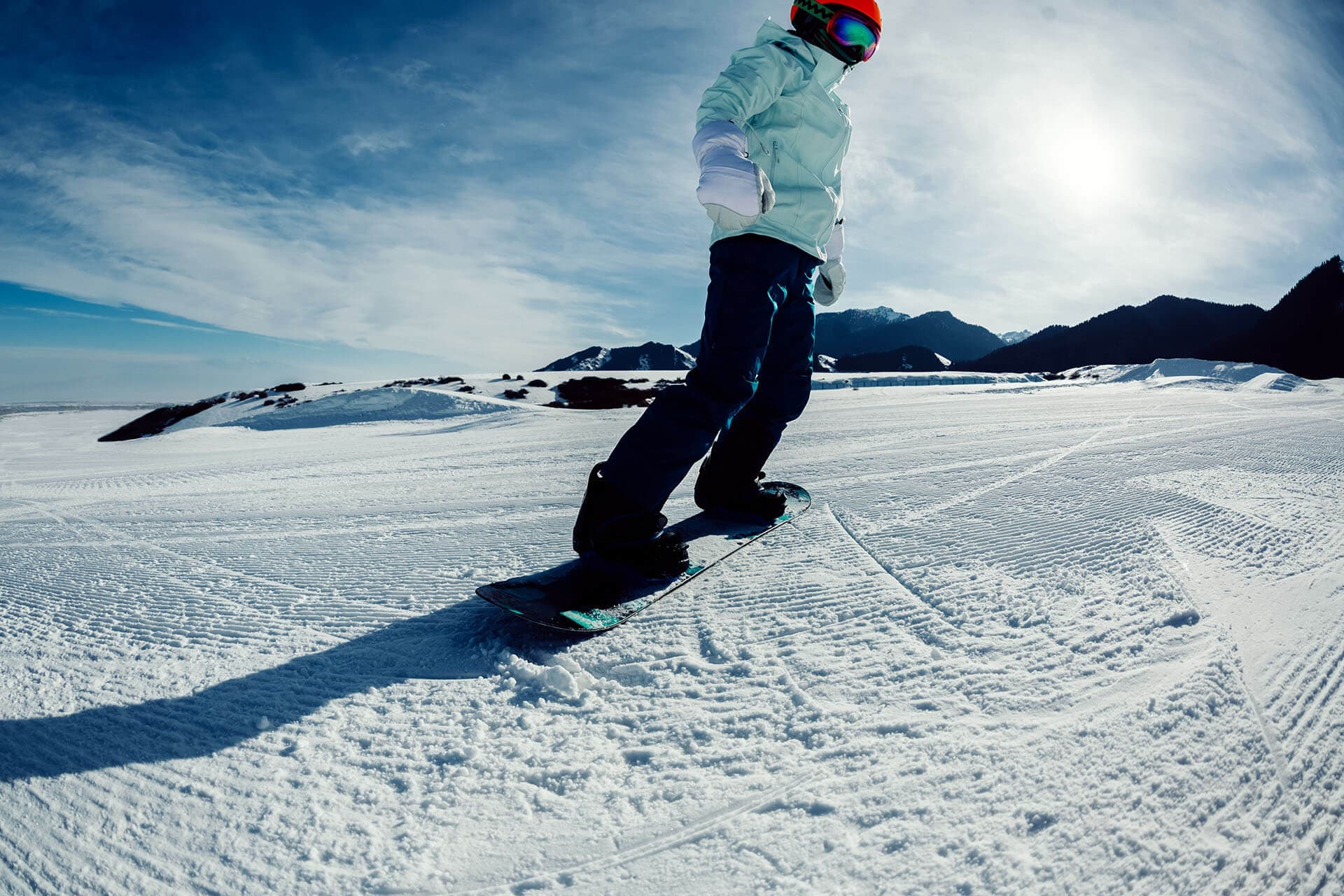 Snowboarder glijdt over een zonnige piste in de Alpen