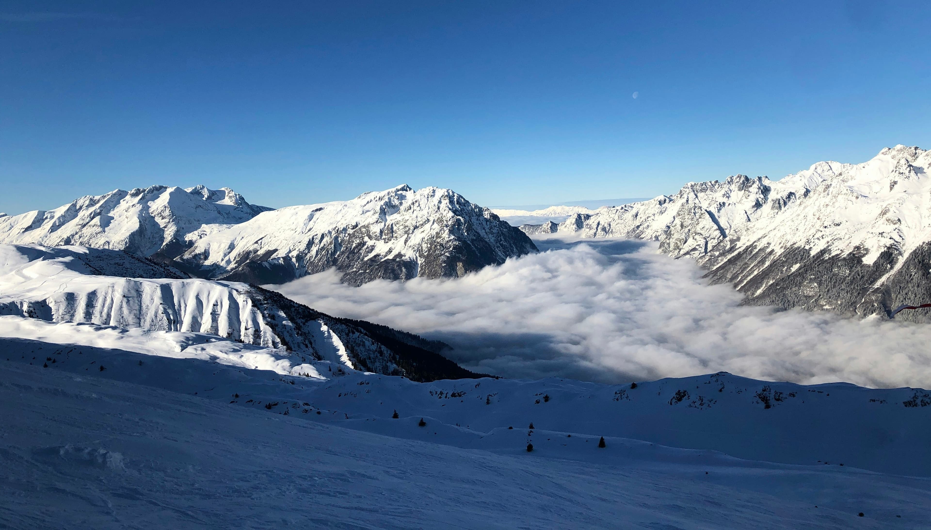Zonnige piste boven een wolkendek op Alpe d'Huez