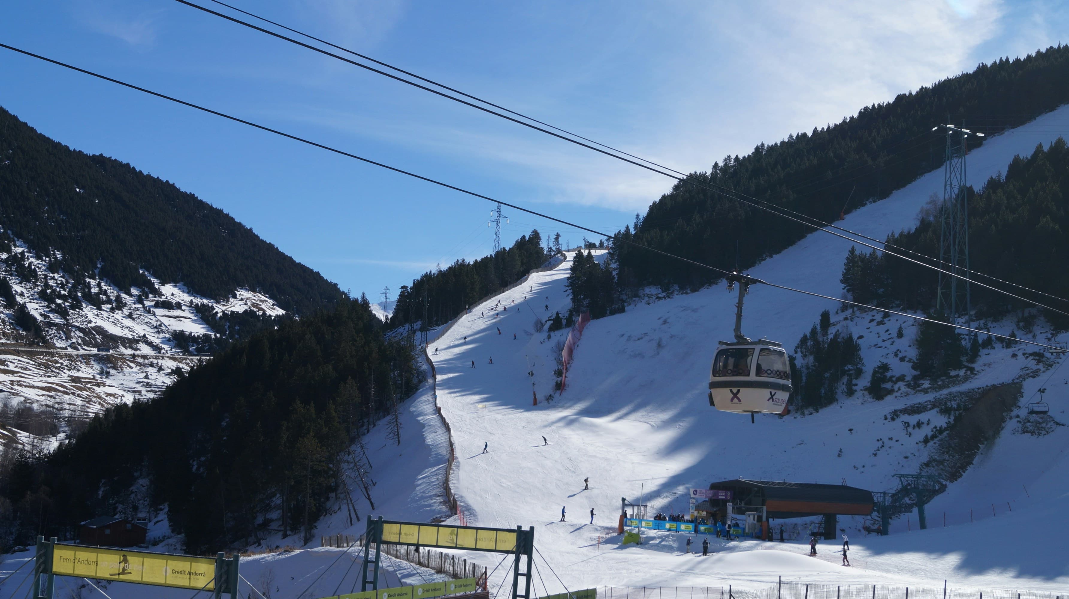 Gondels boven een zonnig besneeuwd dal in Andorra
