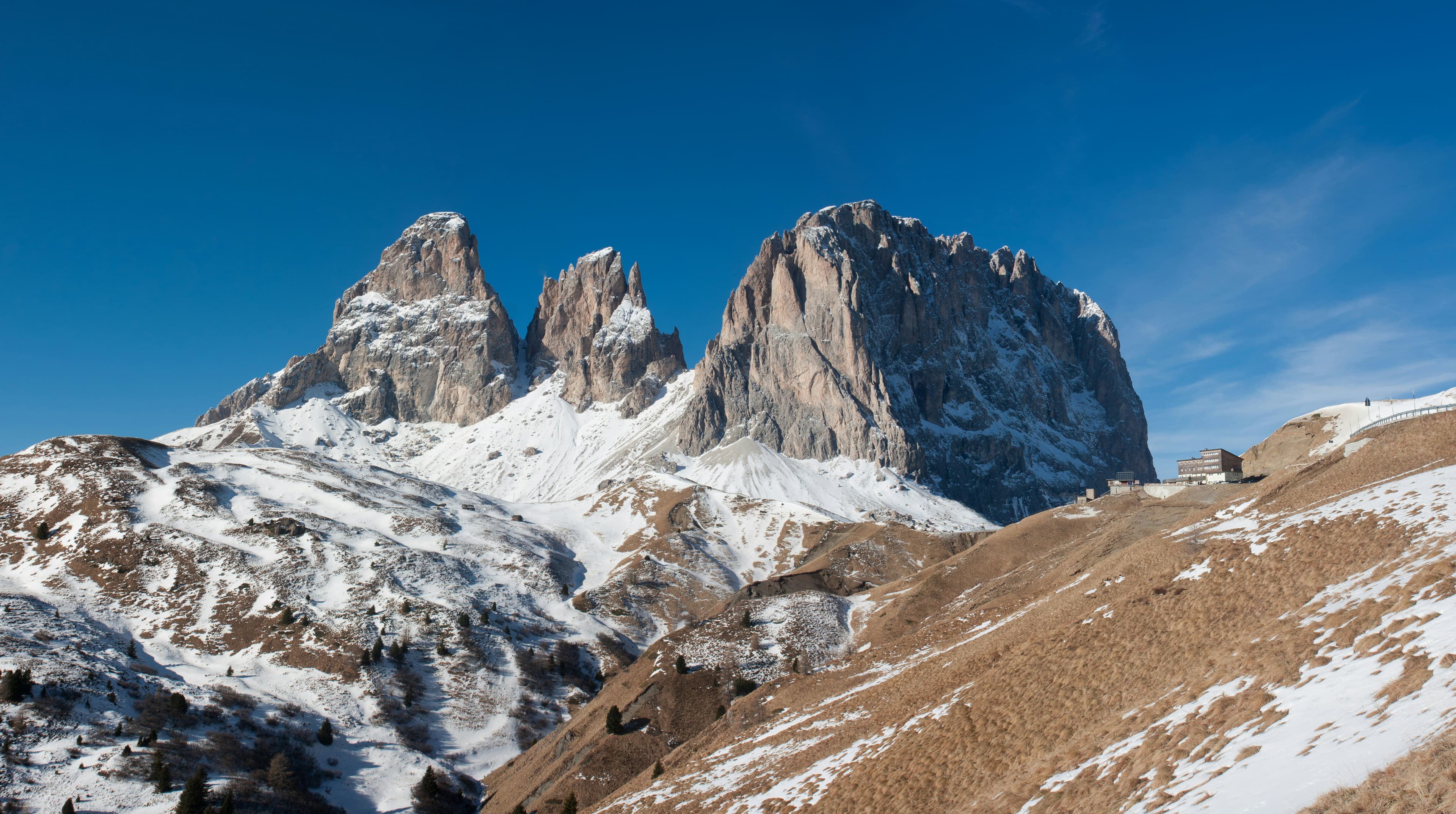 Besneeuwde Dolomietentoppen onder een blauwe lucht in Val di Fassa