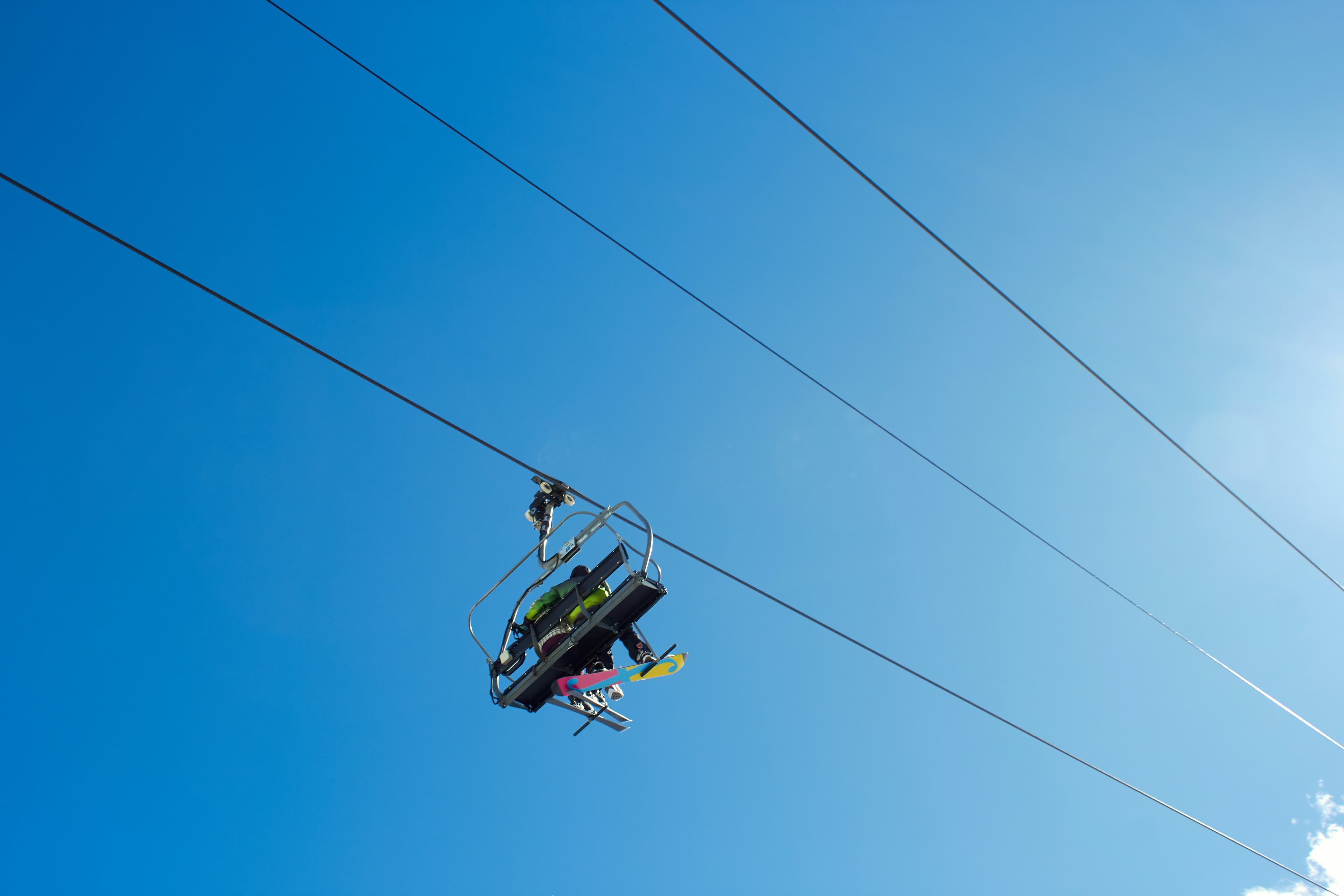 Skiërs in een stoeltjeslift onder een blauwe lucht in Andorra