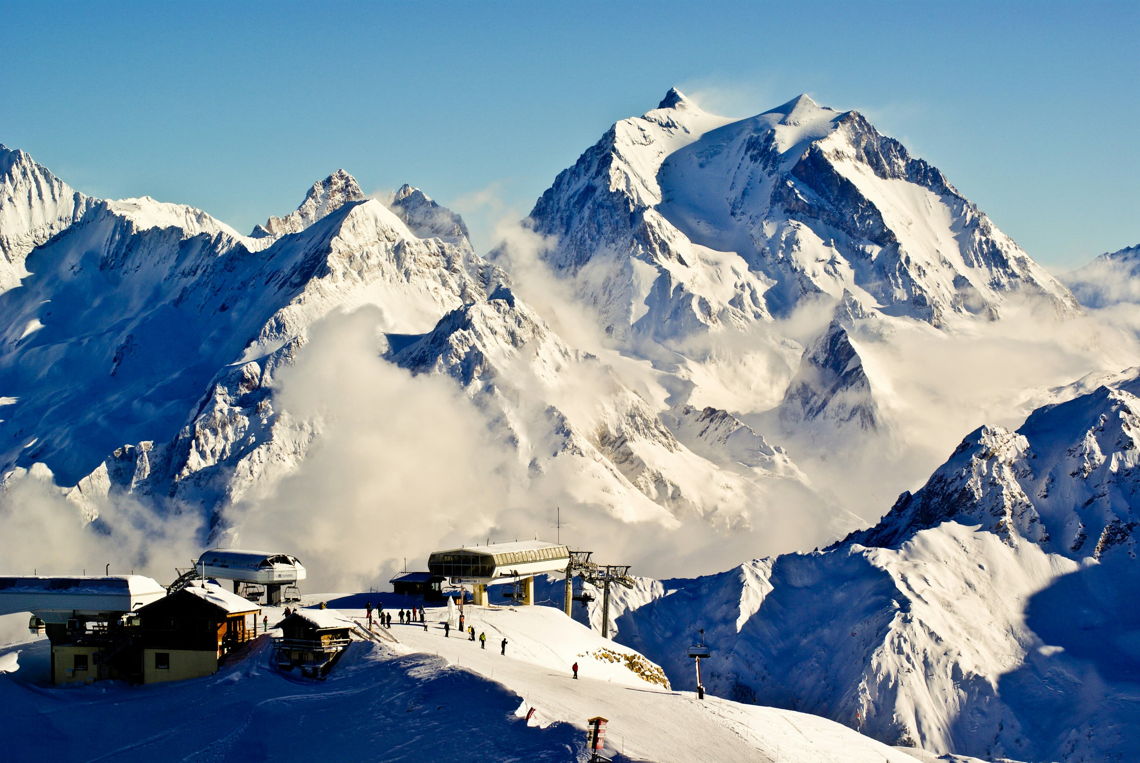Skiliften en chalets van Courchevel onder besneeuwde toppen in Les 3 Vallées