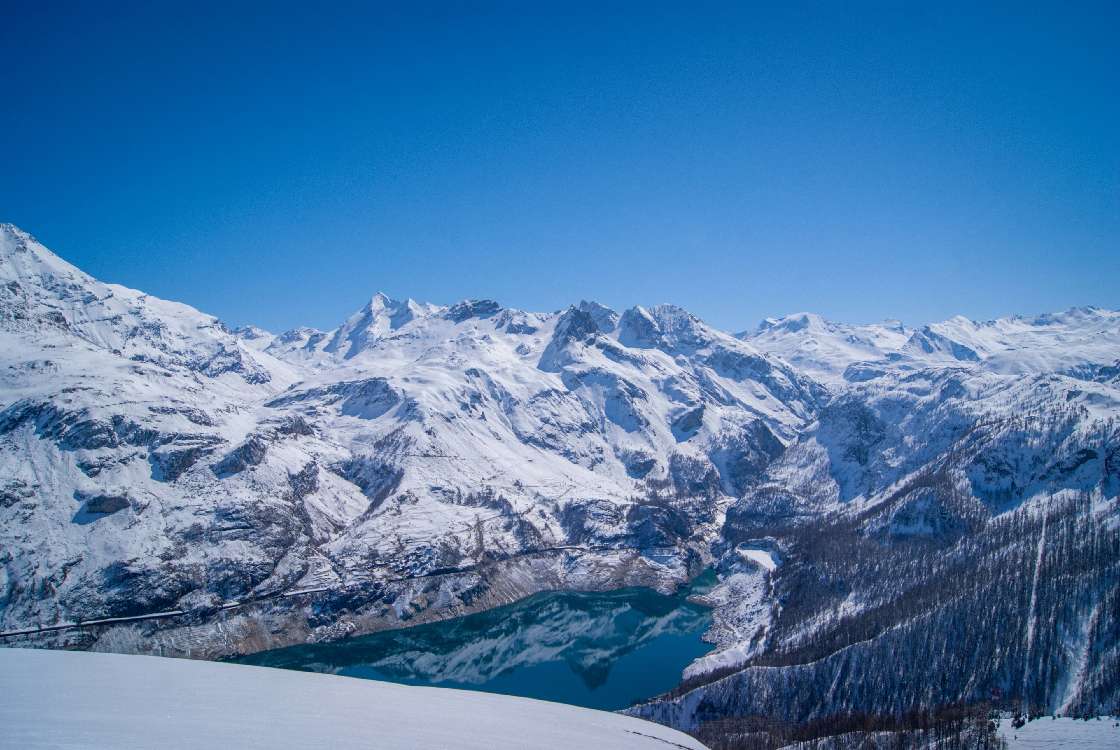 Het meer van Tignes tussen zonnige besneeuwde bergen
