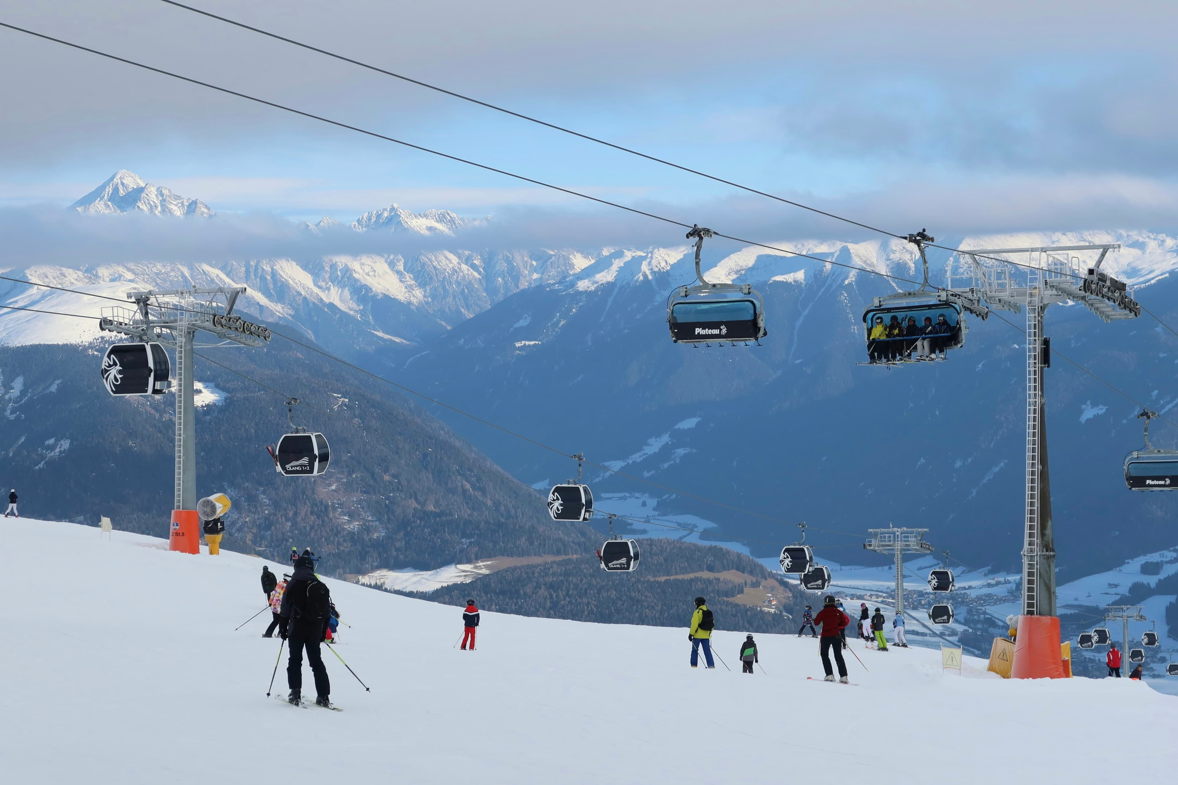 Skiërs bij een stoeltjeslift op een zonnige dag op de Kronplatz