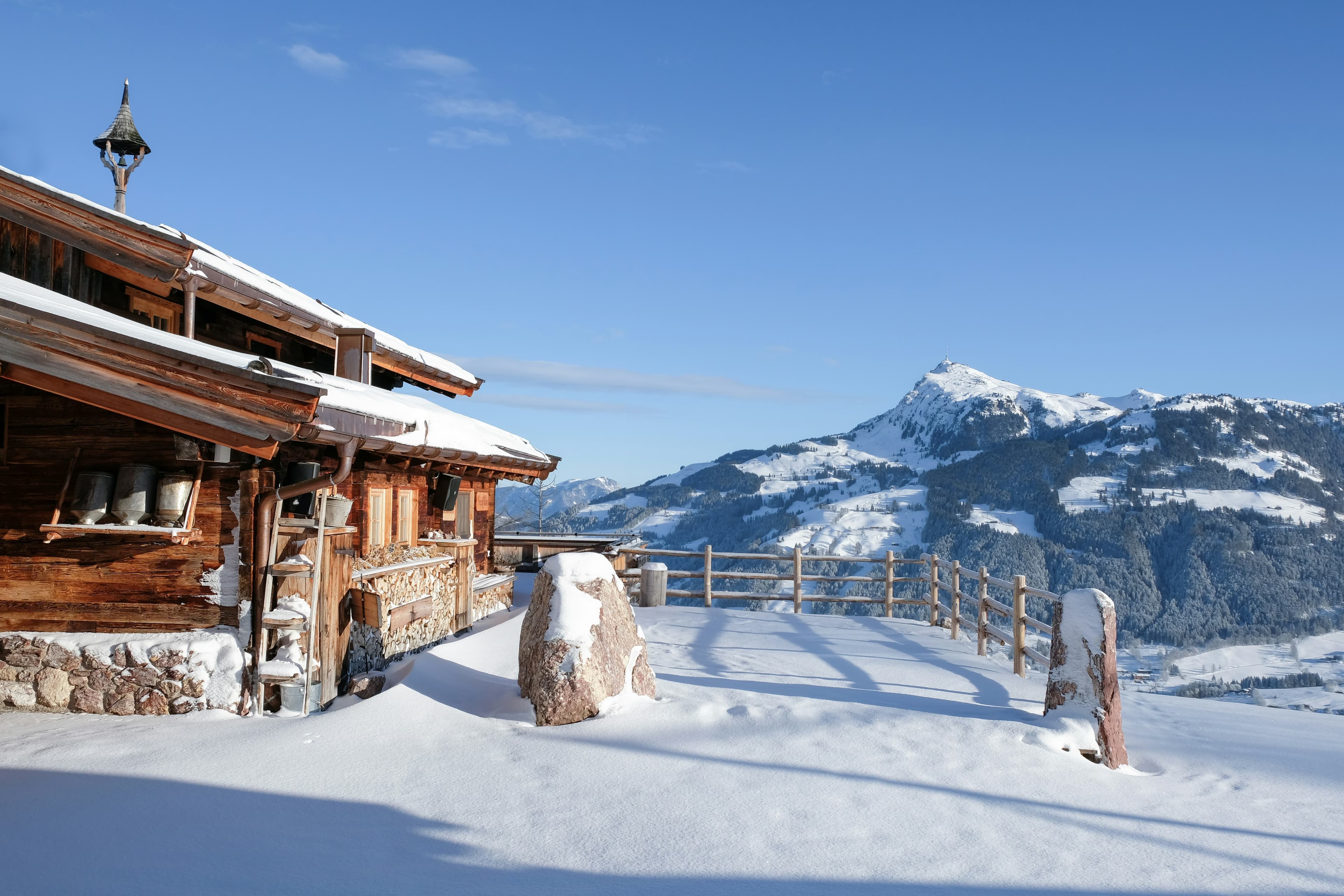 Houten berghut in de zon met uitzicht over de bergen van Kitzbühel