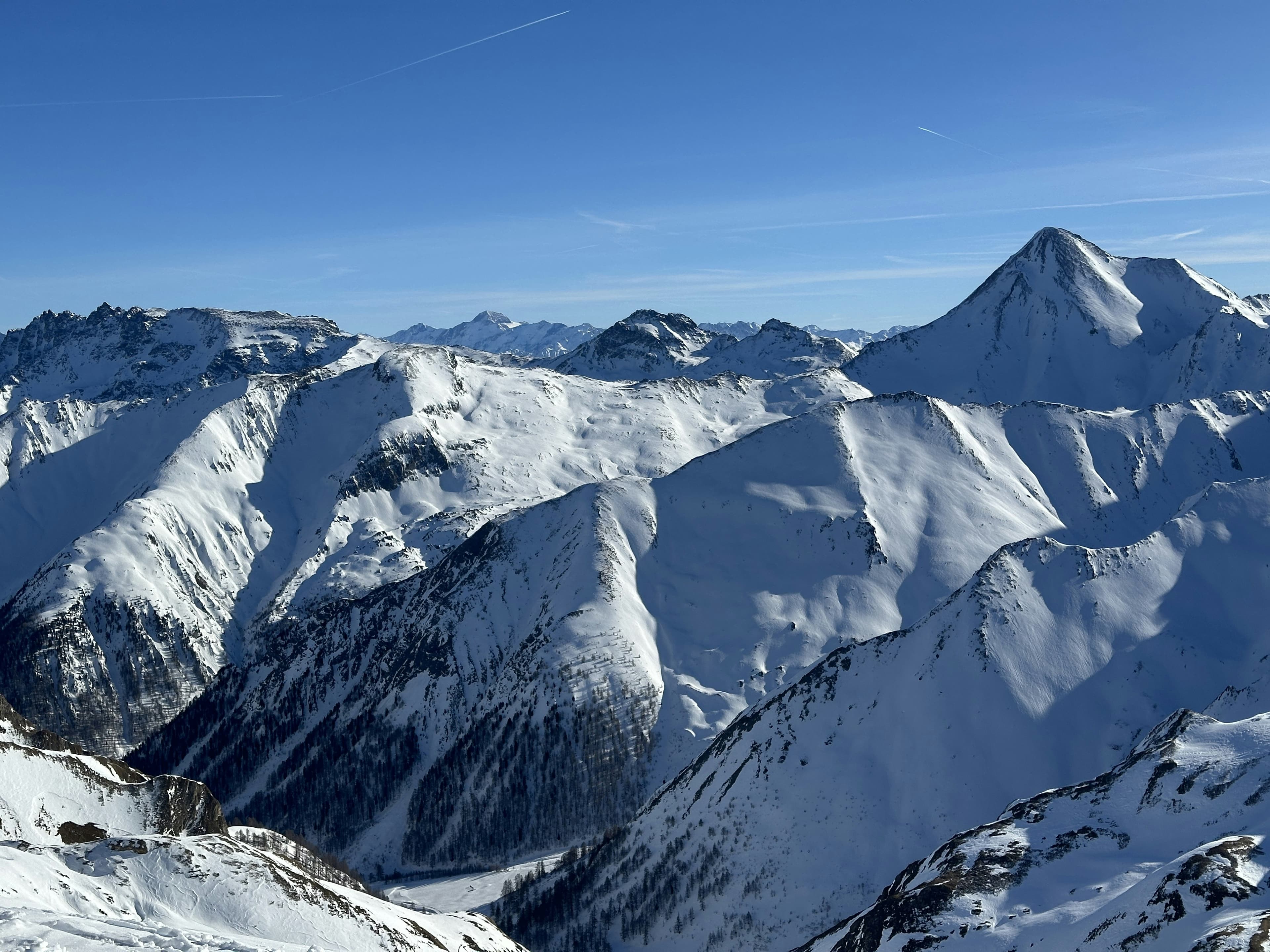 Besneeuwde bergtoppen onder een strakblauwe lucht rond Ischgl