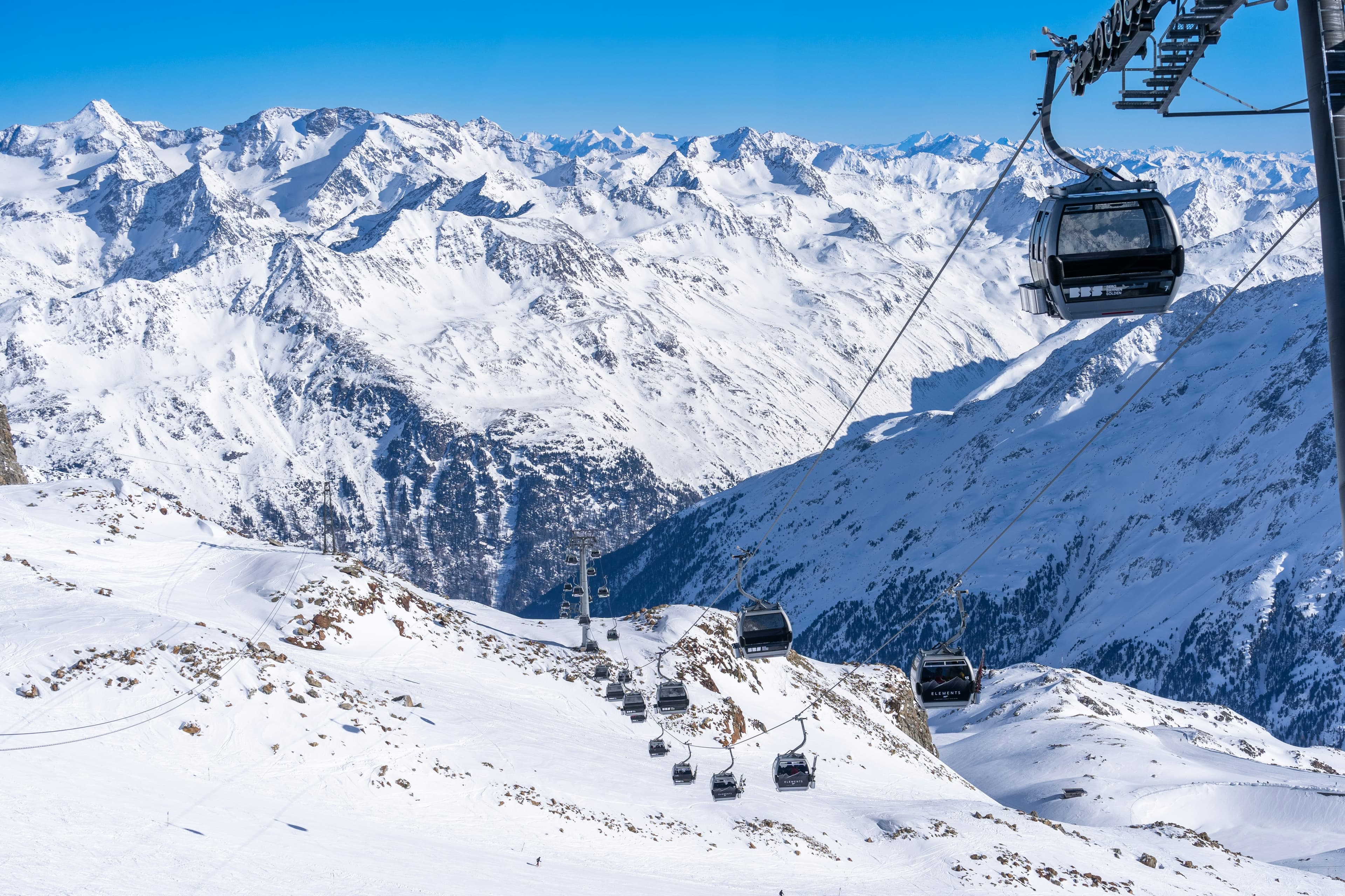 Gondels boven de besneeuwde gletsjerbergen van Sölden