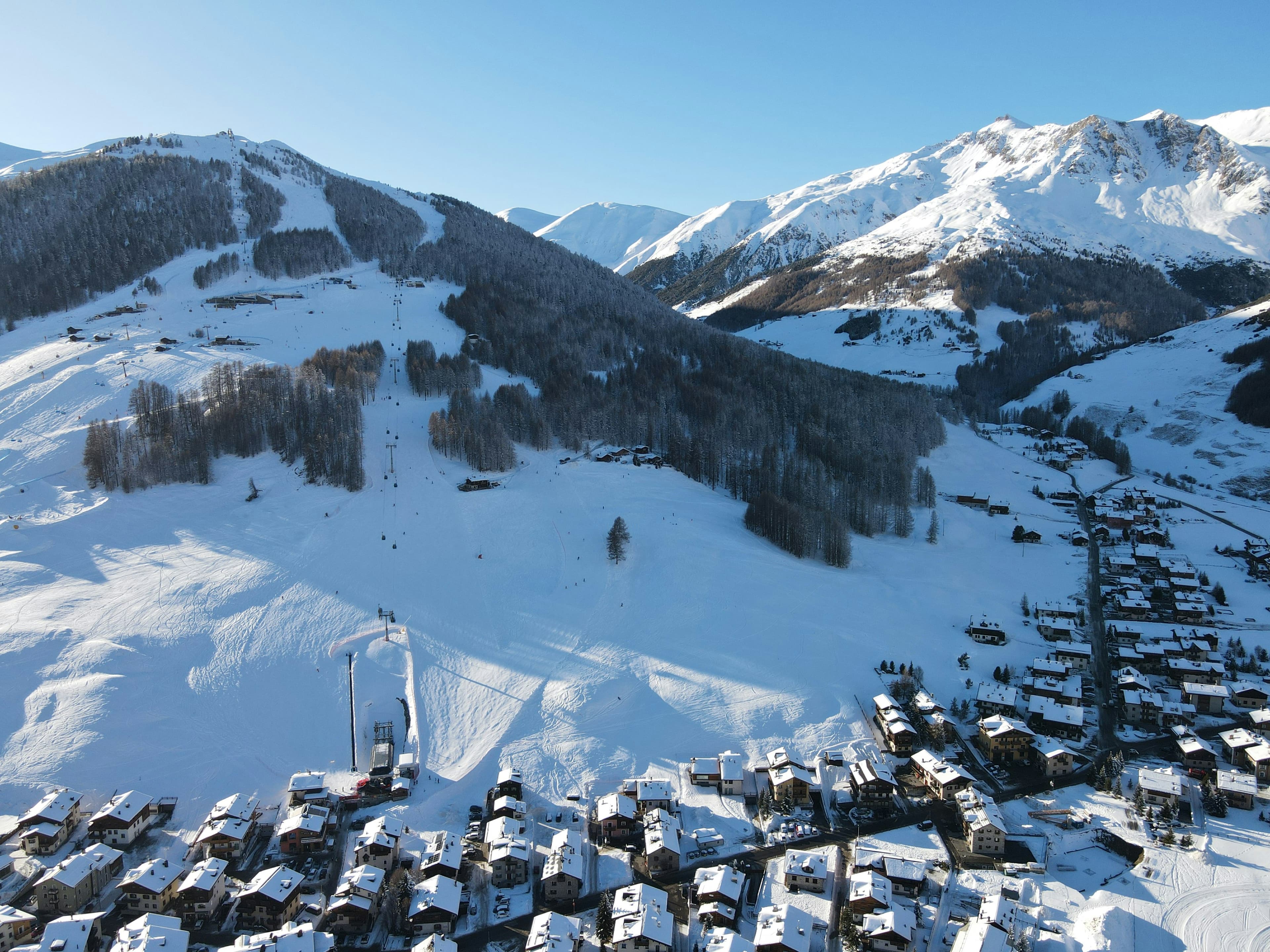 Het skidorp Livigno onder besneeuwde bergen en een blauwe lucht