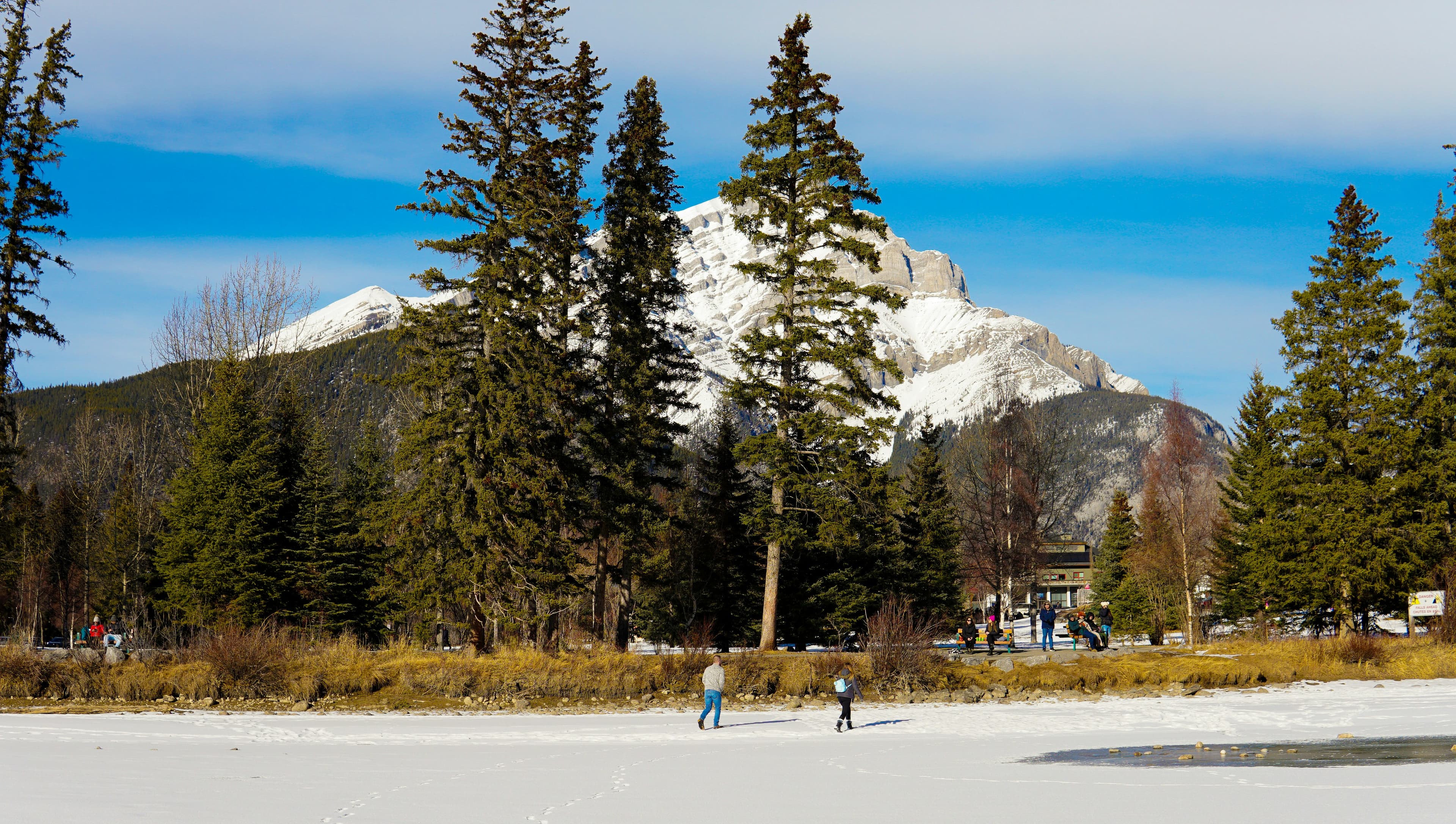 Schaatsers op een bevroren meer met besneeuwde bergen