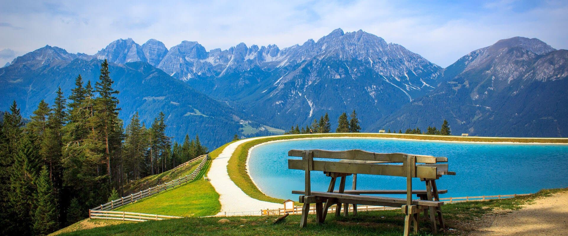 Bankje bij een turquoise bergmeer in de zomerse Oostenrijkse Alpen