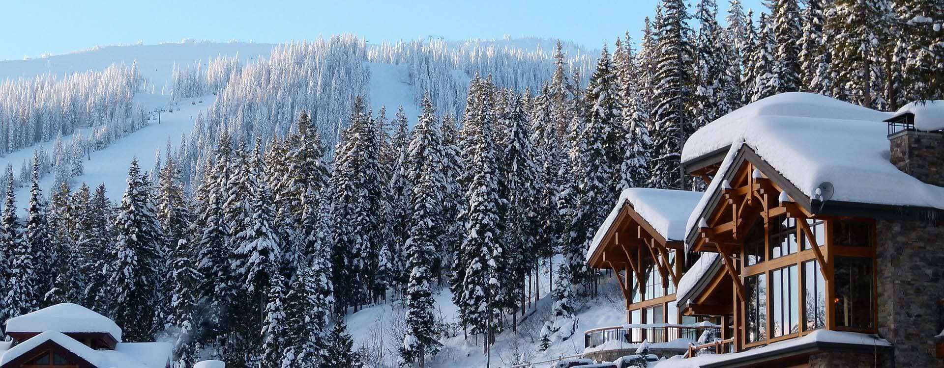 Houten skilodge tussen besneeuwde dennenbossen in Canada