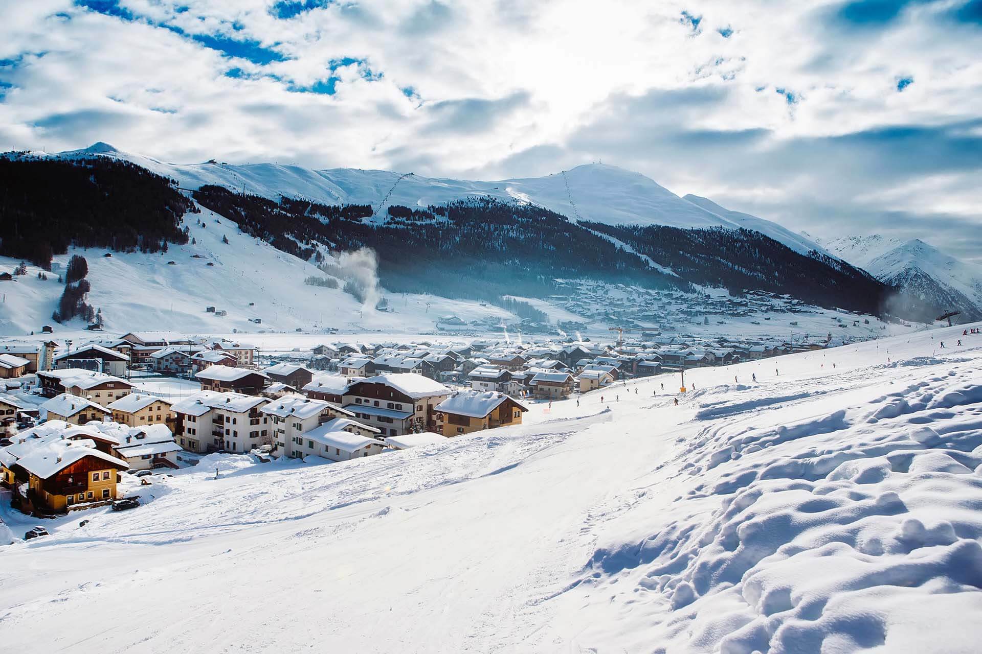 Besneeuwd bergdorp in een brede vallei in de Italiaanse Alpen