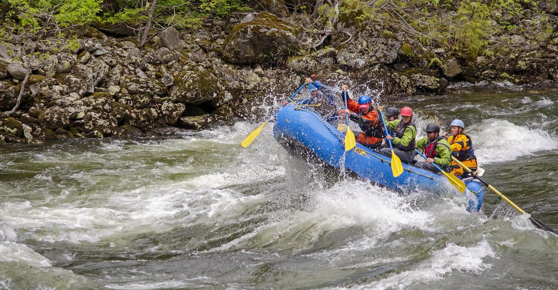 Raftteam peddelt door wild water van een bergrivier