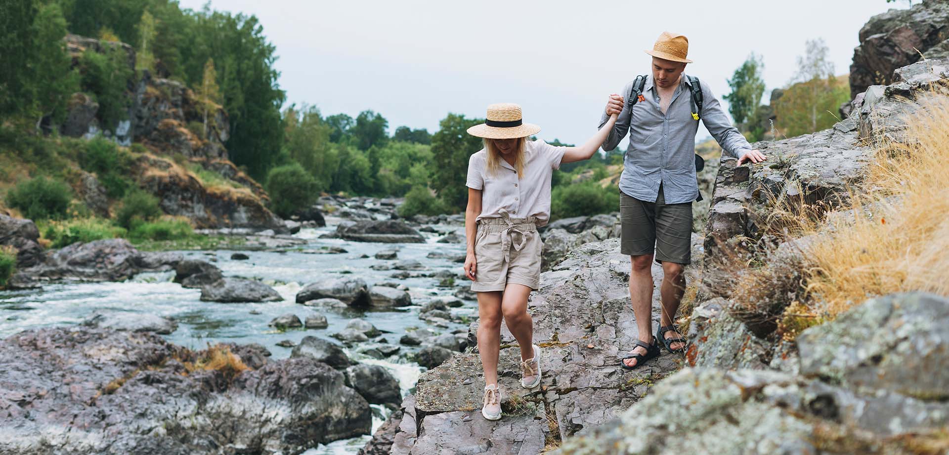 Wandelstel stapt hand in hand langs een bergrivier