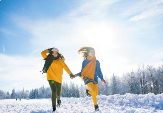 Vrolijke vrienden wandelen samen door de sneeuw